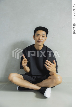 座っているキャップの男性 117769147