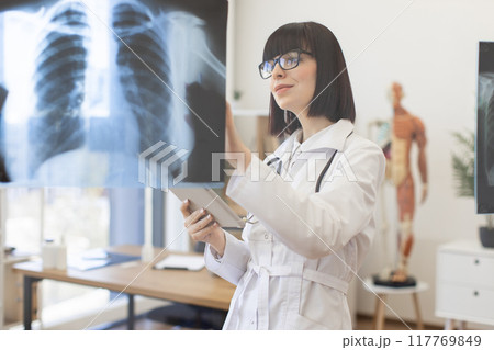 Female doctor examining chest x-rays in medical office 117769849