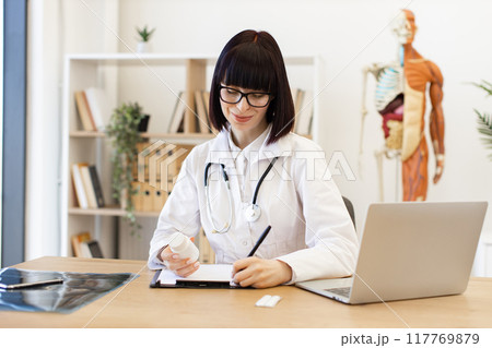 Female doctor writing prescription in medical office Female doctor writing prescription in medical office 117769879