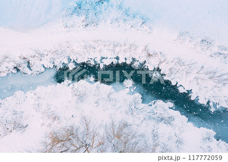 Stunning Aerial View Capturing the Beautiful, Snowy Winter Landscape Featuring a River Stunning Aerial View Capturing the Beautiful, Snowy Winter Landscape Featuring a River 117772059