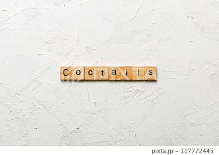 cocktails word written on wood block. cocktails text on cement table for your desing, concept cocktails word written on wood block. cocktails text on cement table for your desing, concept 117772445