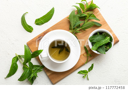 Cup of mint tea on table background. Green tea with fresh mint top view with copy space Cup of mint tea on table background. Green tea with fresh mint top view with copy space 117772458