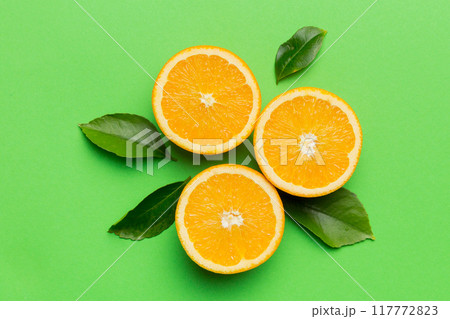 Fruit pattern of fresh orange slices on colored background. Top view. Copy Space. creative summer concept. Half of citrus in minimal flat lay 117772823