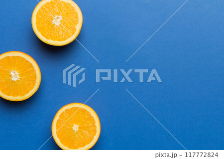 fresh Fruit orange slices on colored background. Top view. Copy Space. creative summer concept. Half of citrus in minimal flat lay with copy space 117772824