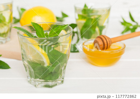 Mojito cocktail. Refreshing mojito cocktail with lime, lemon and mint in a tall glass with a stick Mojito cocktail. Refreshing mojito cocktail with lime, lemon and mint in a tall glass with a stick 117772862