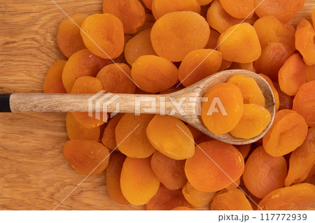 heap of dried apricots on wooden background 117772939