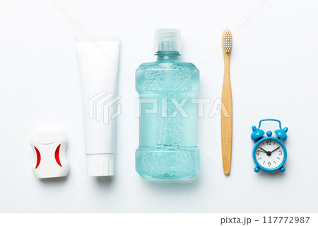 Mouthwash and other oral hygiene products on colored table top view with copy space. Flat lay. Dental hygiene. Oral care products and space for text on light background. concept 117772987