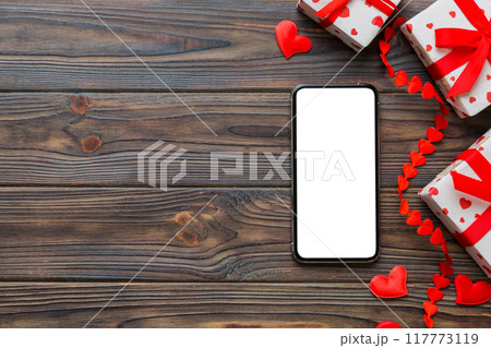 mobile phone with blank screen on colored background with hearts, valentine day concept top view flat lay 117773119