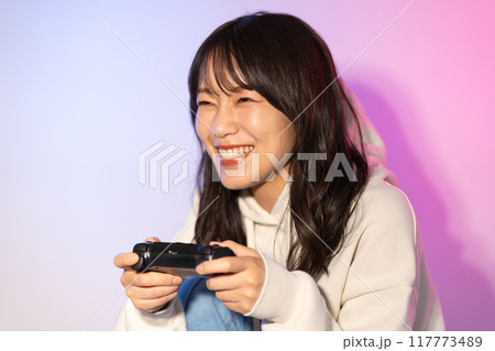白パーカーを着た若い女性ポートレート(ゲーム、コントローラー) 白パーカーを着た若い女性ポートレート(ゲーム、コントローラー) 117773489