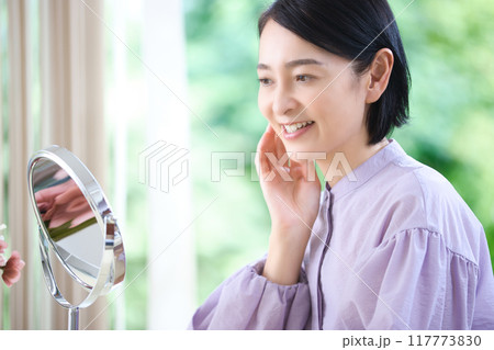 リビングでスキンケアをするミドル女性 117773830