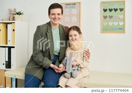 Portrait of Smiling Woman Sitting Beside Girl Holding Toy 117774404