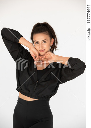 Young athlete girl posing in a black leggings and shirt. indoors Young athlete girl posing in a black leggings and shirt. indoors 117774665