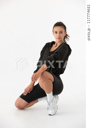 Young athlete girl posing in a black leggings and shirt. indoors 117774681