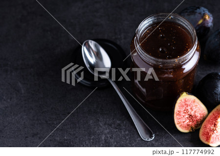 Tasty sweet jam and fresh figs on black slate background Tasty sweet jam and fresh figs on black slate background 117774992