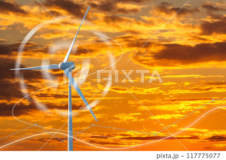 A wind turbine is spinning in the sky above a sunset 117775077