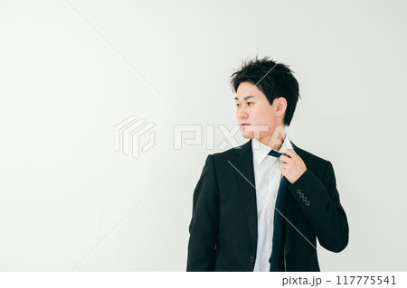 ネクタイを緩めながら横を見る20代男性 117775541