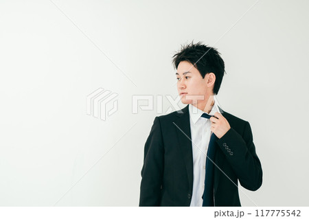 ネクタイを緩めながら横を見る20代男性 ネクタイを緩めながら横を見る20代男性 117775542