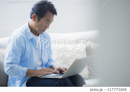 リビングでノートパソコンを使うミドル男性 リビングでノートパソコンを使うミドル男性 117775806