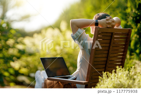 woman working on laptop in summer morning 117775938