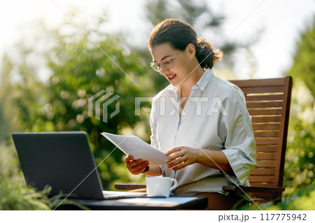 woman working on laptop in summer morning woman working on laptop in summer morning 117775942