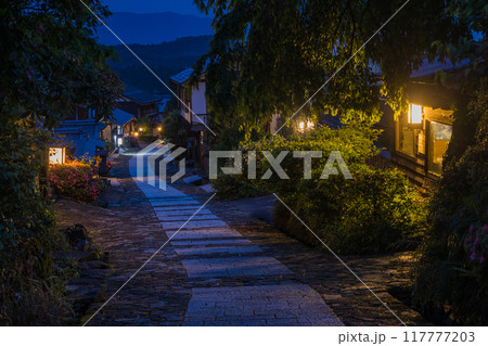日本　岐阜県中津川市にある中山道の宿馬町、馬籠宿の石畳の坂道とライトアップされた夜の町並み 117777203