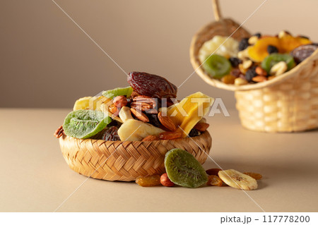 Dried tropical fruits, nuts and raisins on a beige background. Dried tropical fruits, nuts and raisins on a beige background. 117778200