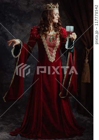 Full length portrait of medieval queen in red dress with goblet Full length portrait of medieval queen in red dress with goblet 117778542