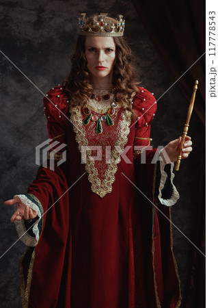 medieval queen in red dress with wand and crown medieval queen in red dress with wand and crown 117778543
