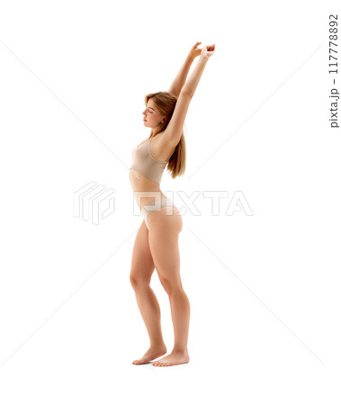 Full-length image of young beautiful woman with fit healthy body posing in underwear isolated on white background. Stretching. Full-length image of young beautiful woman with fit healthy body posing in underwear isolated on white background. Stretching. 117778892