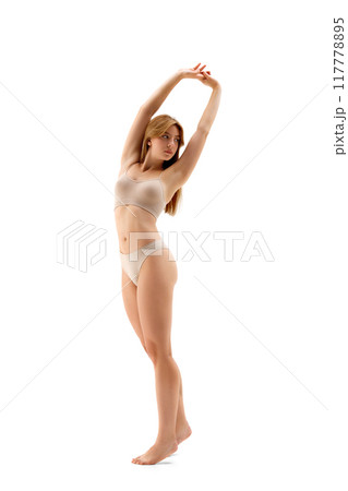 Full-length image of young beautiful woman with fit healthy body posing in underwear isolated on white background. Stretching. Full-length image of young beautiful woman with fit healthy body posing in underwear isolated on white background. Stretching. 117778895