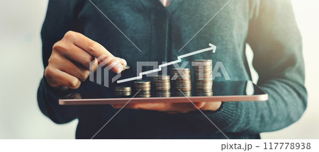 person is holding a tablet with a graph of money on it person is holding a tablet with a graph of money on it 117778938