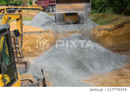 Construction site irregularities are filled with granite rubble base prior to concrete foundation being built Construction site irregularities are filled with granite rubble base prior to concrete foundation being built 117779354