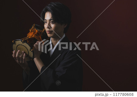 和楽器を演奏する紋付袴の男性 117780608