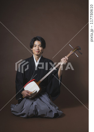 和楽器を演奏する紋付袴の男性 和楽器を演奏する紋付袴の男性 117780610