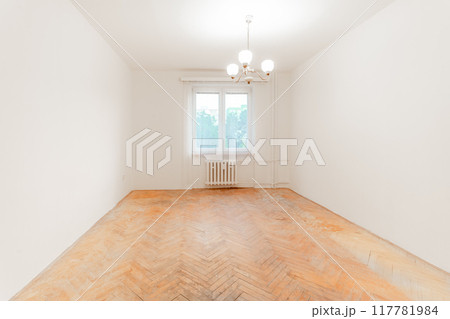 Empty room with worn parquet flooring awaiting renovation Empty room with worn parquet flooring awaiting renovation 117781984