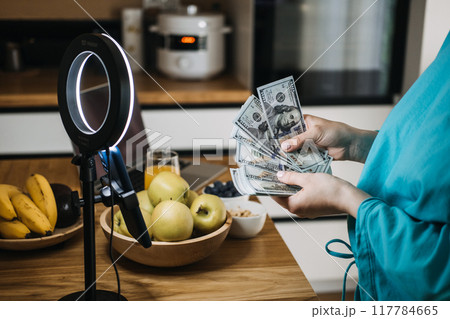 Content creator counting money during live stream, influencer marketing, financial success, digital entrepreneurship, online earnings, social media revenue 117784665