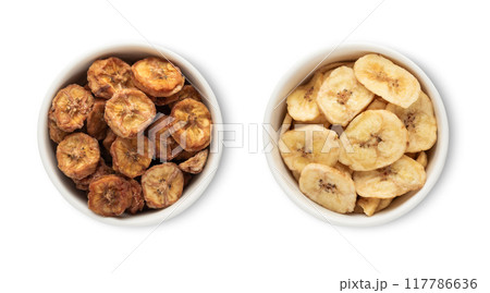 Bowls with dried healthy organic banana bites isolated on white background. 117786636