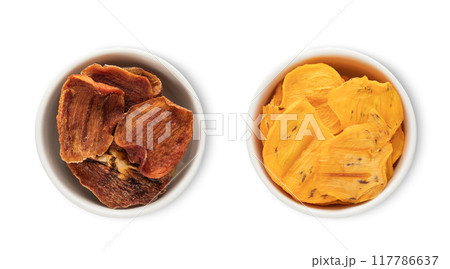 Bowl plates with dried healthy organic persimmon kaki pieces isolated on white background. 117786637