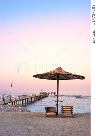 Photo of an empty beach at a purple sunset. Photo of an empty beach at a purple sunset. 117787285