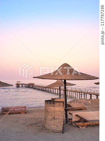 Photo of an empty beach at a purple sunset. Photo of an empty beach at a purple sunset. 117787286