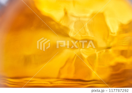 A blurred image of amber glass. Abstraction with space to copy. High quality photo 117787292