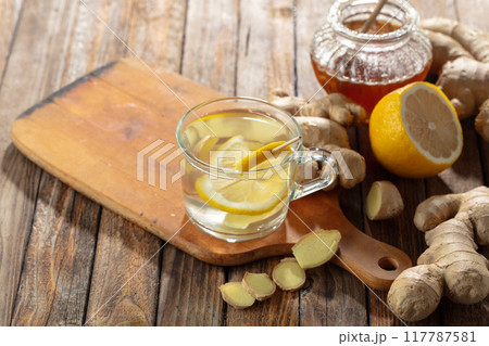 Ginger tea with lemon and honey on a old wooden table. Ginger tea with lemon and honey on a old wooden table. 117787581