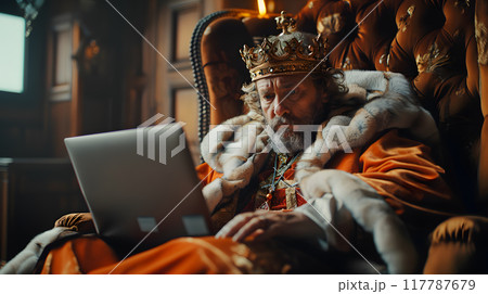 King sits on a lavish throne, wearing traditional attire and using a laptop while surrounded by an opulent setting. King sits on a lavish throne, wearing traditional attire and using a laptop while surrounded by an opulent setting. 117787679