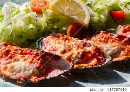 baked mussels with masago caviar and cheese on a white plate baked mussels with masago caviar and cheese on a white plate 117787919
