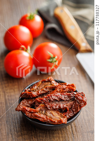Sun dried red tomatoes on wooden table. Sun dried red tomatoes on wooden table. 117788327