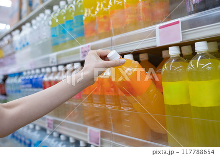 ペットボトル入りのジュースを選ぶ女性の手 117788654