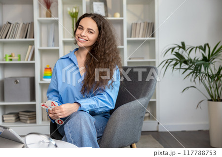 Smiling young speech therapist feeling happy after a good session 117788753