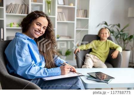 Long-haired female speech therapist working with a hard child and trying to make him feel comfortable 117788775
