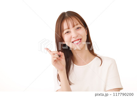 笑顔で指差しポーズをする女性（白背景） 117790200