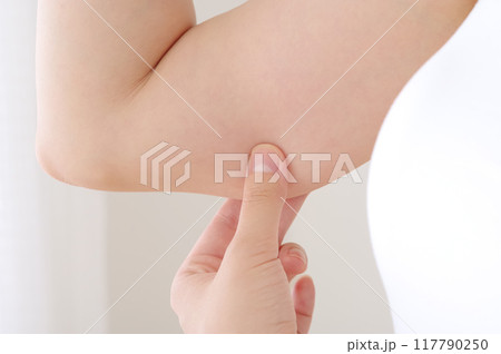 二の腕をつまむ若い女性 117790250